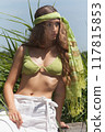 Summery boho look: close-up of a young woman in a green bikini top and headscarf 117815853