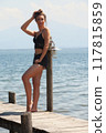 Casual summer look at the lake: woman on a jetty in black lace 117815859