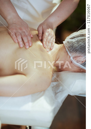 Medical massage therapist in massage cabinet massaging client Medical massage therapist in massage cabinet massaging client 117816067