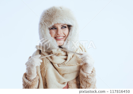 happy modern woman in winter coat and fur hat on white 117816450