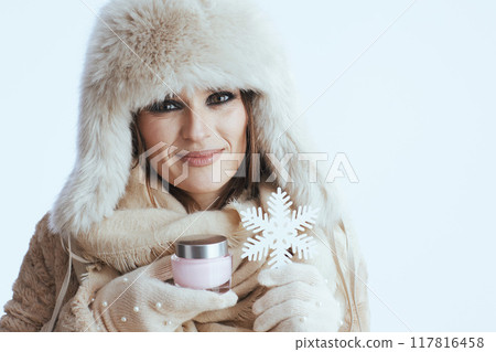 smiling modern woman in winter coat and fur hat on white 117816458