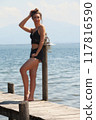 Casual summer look at the lake: woman on a jetty in black lace 117816590