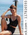 Relaxed summer portrait: Woman in a black lace top by the lake 117816593