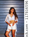 Summery fashion portrait of a young woman in a white lace outfit 117816596