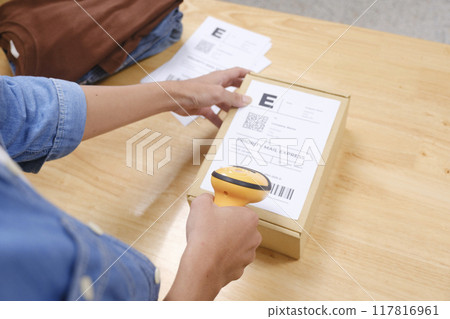 Asian man business owner scanning barcode on delivery parcel. Asian man business owner scanning barcode on delivery parcel. 117816961