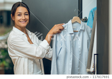 Housewife checking the wardrobe and making clothes revision 117817691