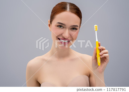 Happy young woman brushing teeth and looking enjoyed Happy young woman brushing teeth and looking enjoyed 117817791