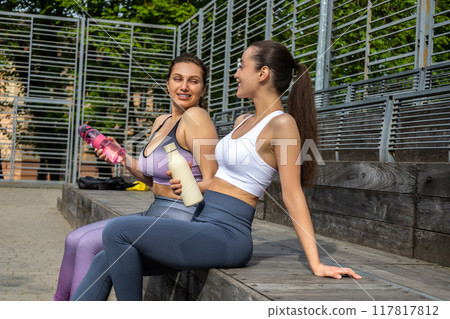 Two young women in sportswear resting after workout 117817812