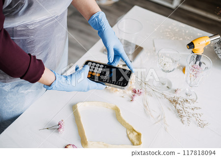 Crafting process with precise measurements, artisan calculating resin mixture. DIY projects, handmade decor, creative hobbies, sustainable crafts, artisan work, floral preservation. Crafting process with precise measurements, artisan calculating resin mixture. DIY projects, handmade decor, creative hobbies, sustainable crafts, artisan work, floral preservation. 117818094