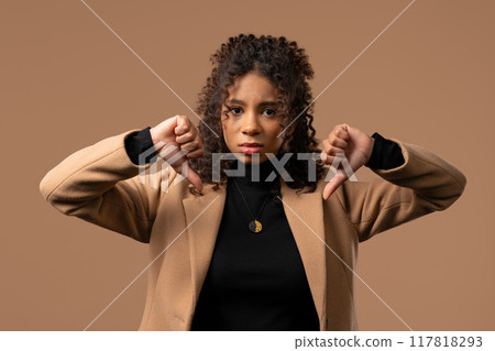 Young teen girl with dislike sign. Stylish african lady showing thumbs-down Young teen girl with dislike sign. Stylish african lady showing thumbs-down 117818293