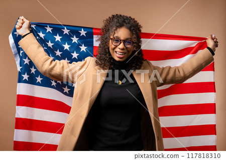 Happy american fan woman with national USA flag on beige. Teenager patriot, US Happy american fan woman with national USA flag on beige. Teenager patriot, US 117818310