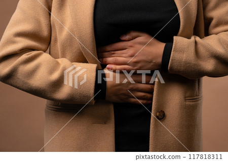 Teenager girl squeezing belly with hands. abdominal pain, suffering stomach ache Teenager girl squeezing belly with hands. abdominal pain, suffering stomach ache 117818311