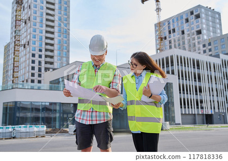 Two industrial construction workers discussing project plan for engineering work Two industrial construction workers discussing project plan for engineering work 117818336