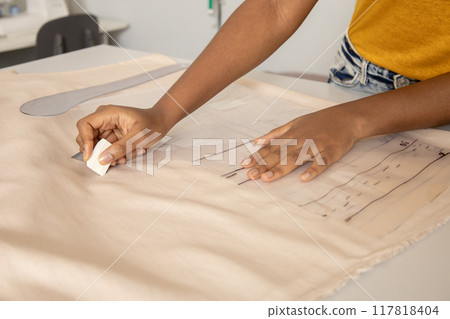Anonymous woman seamstress marking fabric with tailors chalk in workshop Anonymous woman seamstress marking fabric with tailors chalk in workshop 117818404