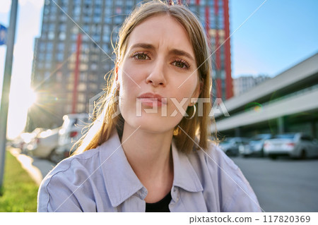 Close-up selfie portrait of teenage confused female looking at web camera 117820369