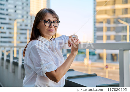 Portrait of middle-aged confident woman posing outdoors Portrait of middle-aged confident woman posing outdoors 117820395
