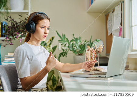 Girl teenage student in headphones having video chat online on computer 117820509