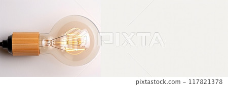 Minimalist design featuring a vintage-style light bulb with a wooden base against a clean, white background. Minimalist design featuring a vintage-style light bulb with a wooden base against a clean, white background. 117821378