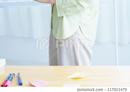 A young woman visualizing issues in the office 117821470