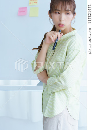 A young woman visualizing issues in the office 117821471