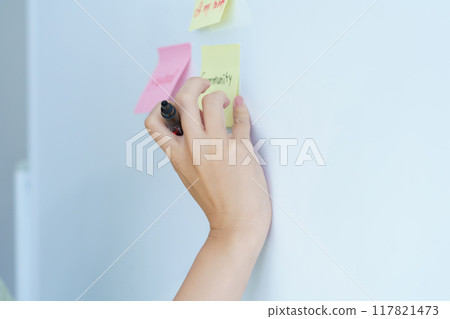 A young woman visualizing issues in the office 117821473