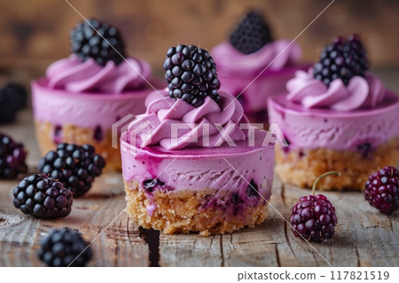 Delicious blackberry cheesecake mini desserts with a crumbly biscuit base and creamy purple filling 117821519