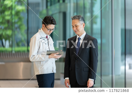 一名穿著工作服的男子在大廳開商務會議 117821868