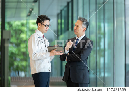 Men in work clothes discussing business in the lobby 117821869