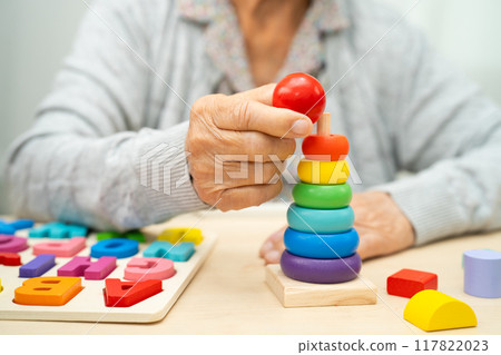 Alzheimer disease AD, Asian senior woman patient suffering from dementia learn practical motor skills rehabilitation. Alzheimer disease AD, Asian senior woman patient suffering from dementia learn practical motor skills rehabilitation. 117822023