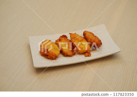 Corn croquettes on a white plate on a wooden table Corn croquettes on a white plate on a wooden table 117823350