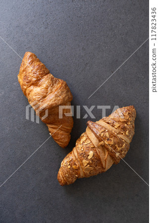 two fresh croissants on a dark background 117823436