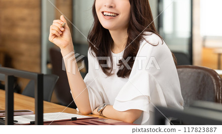 Smiling business woman doing desk work Smiling business woman doing desk work 117823887