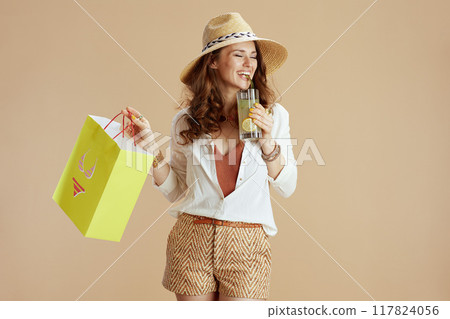 smiling stylish female in blouse and shorts against beige smiling stylish female in blouse and shorts against beige 117824056