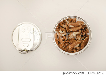 Walnuts in a plastic jar on a white background. 117824242