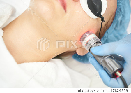 Light infrared therapy. Cosmetology head procedure. Beauty woman face. Cosmetic Light infrared therapy. Cosmetology head procedure. Beauty woman face. Cosmetic 117824839