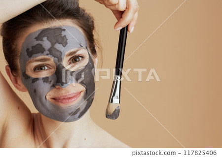 smiling young female with brush and cosmetic mask smiling young female with brush and cosmetic mask 117825406