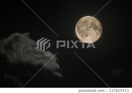 The moon is in the night sky with clouds. Full moon 117825413