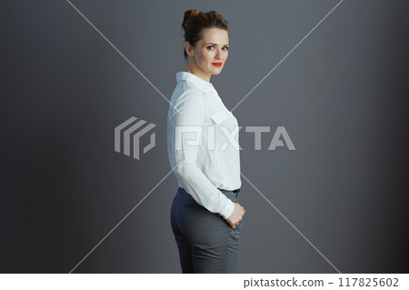 trendy female employee in white blouse against gray background 117825602