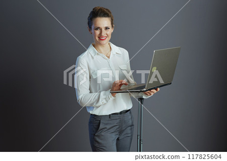 smiling elegant business owner woman isolated on gray 117825604
