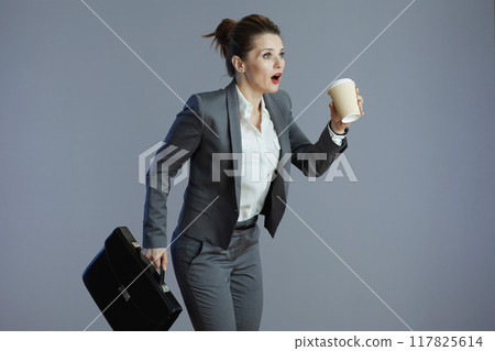 trendy woman employee running against gray background trendy woman employee running against gray background 117825614