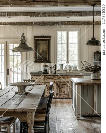 A rustic farmhouse kitchen with exposed beams, a farmhouse table, and a window overlooking the outdoors A rustic farmhouse kitchen with exposed beams, a farmhouse table, and a window overlooking the outdoors 117826539
