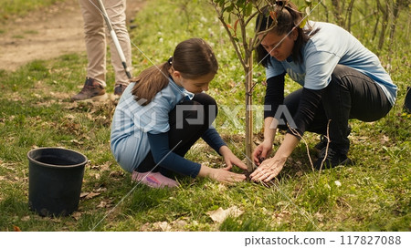 Diverse volunteers team planting trees seeds in the forest, digging holes to preserve natural habitat and cultivate life after. People fighting ecological justice, environmental care. Camera A. 117827088