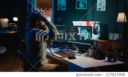 Man puts EEG headset on to transfer mind into computer virtual world, becoming one with AI superintelligence. Engineer using futuristic neuroscientific technology to transfer consciousness, camera B Man puts EEG headset on to transfer mind into computer virtual world, becoming one with AI superintelligence. Engineer using futuristic neuroscientific technology to transfer consciousness, camera B 117827099