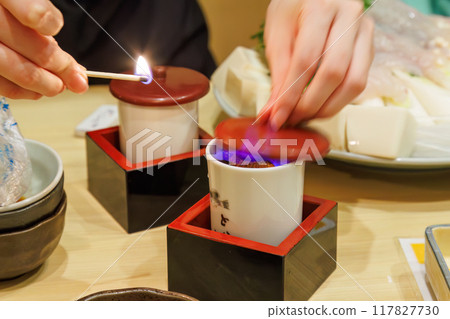 Tiger pufferfish fin sake. Add grilled pufferfish fins to hot sake. Flambé it just before drinking to evaporate the alcohol. 117827730