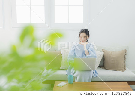一位女士在客廳使用電腦 117827845