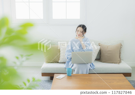 一位女士在客廳使用電腦 117827846