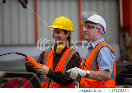 Professional team technician engineer factory workers use control remote for controlling industrial Professional team technician engineer factory workers use control remote for controlling industrial 117828254