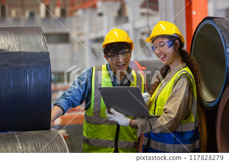 female and male wearing safety uniform worker use laptop checking quality product metal sheet female and male wearing safety uniform worker use laptop checking quality product metal sheet 117828279