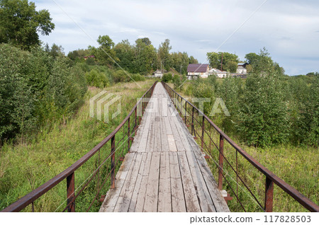 Wooden pedestrian bridge with iron railings 117828503