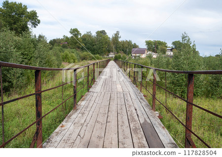 Wooden pedestrian bridge with iron railings 117828504